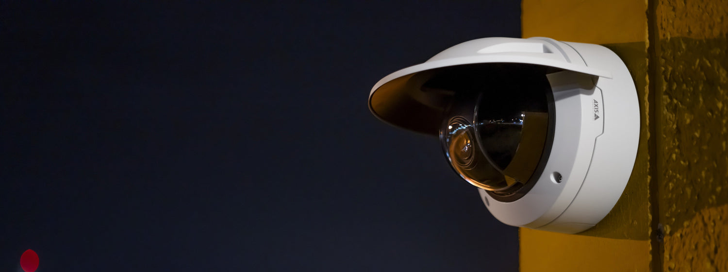 q3546 l v e camera with weathershield mounted on the wall at night.